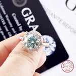 Silver ring with a large gemstone held by a hand, with 'GRA' and 'Real Sterling Silver' text in the background.