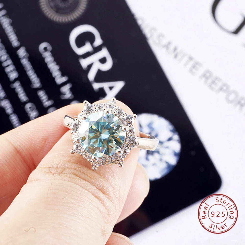 Silver ring with a large gemstone held by a hand, with 'GRA' and 'Real Sterling Silver' text in the background.