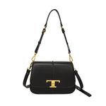 Black handbag with gold accents on a white background