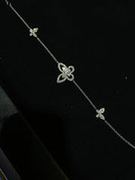 Delicate silver necklace with butterfly-shaped pendants on a black background