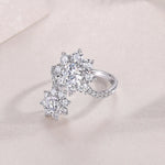 Silver ring with diamond-like stones on a light pink background