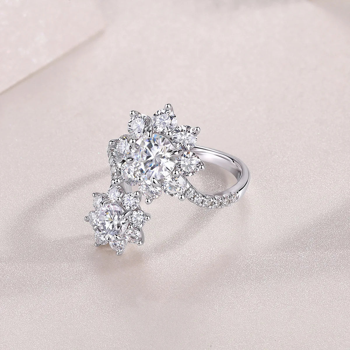 Silver ring with diamond-like stones on a light pink background
