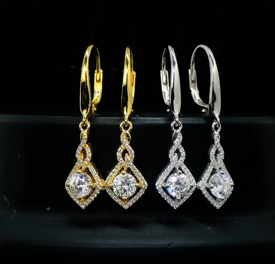 Pair of gold and silver earrings on a black background