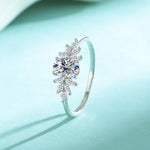 Silver ring with a large central gemstone on a light blue background