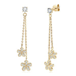 Gold flower-shaped earrings with clear stones on a white background, featuring the TBCY Fine Jewelry logo.