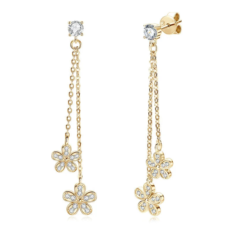 Gold flower-shaped earrings with clear stones on a white background, featuring the TBCY Fine Jewelry logo.