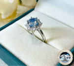 Silver ring with blue gemstone in a jewelry box, featuring the brand 'Joyce Jelly'.