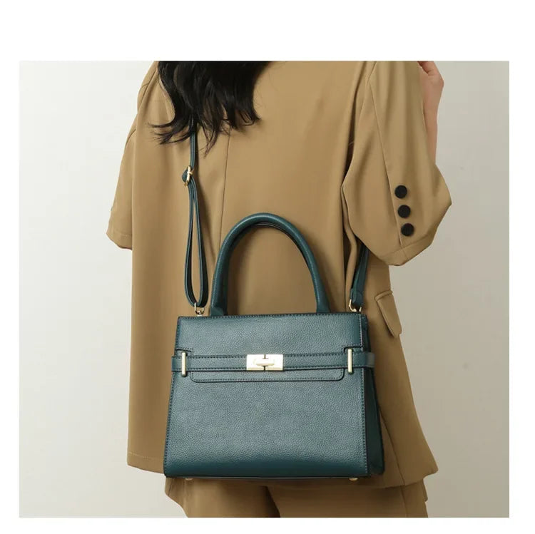Green handbag worn by a person in a beige coat against a neutral background
