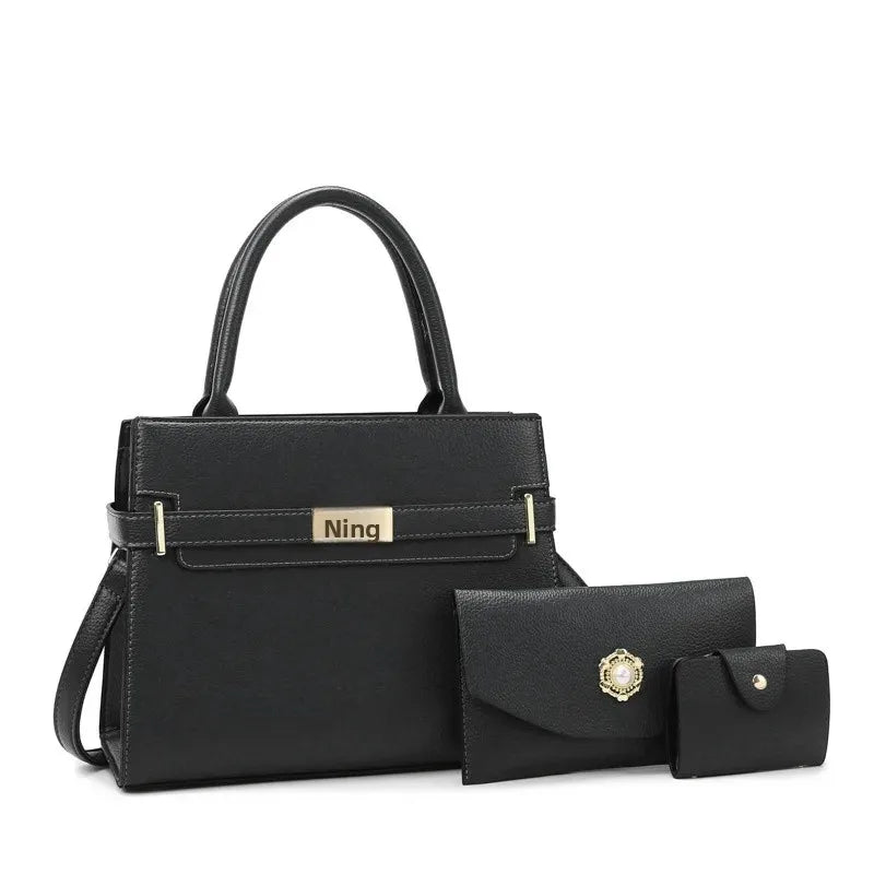 Black handbag with matching wallet and pouch on a white background