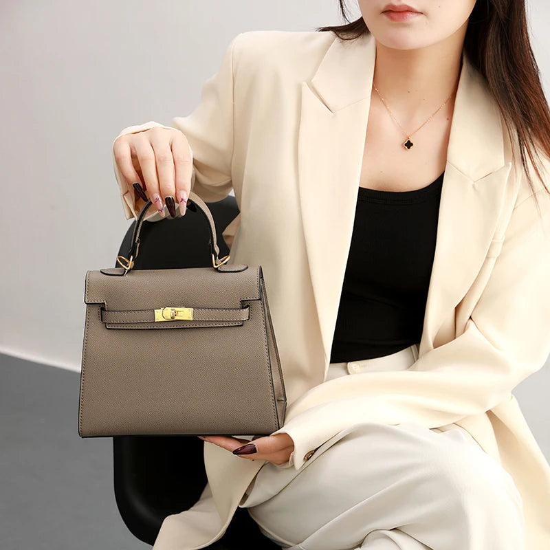Woman holding a gray handbag with a neutral background