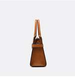 Brown handbag with tan handles on a light gray background