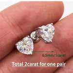 Heart-shaped diamond earrings on a hand with size and weight information displayed.