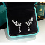 Pair of silver earrings on a black and turquoise jewelry box