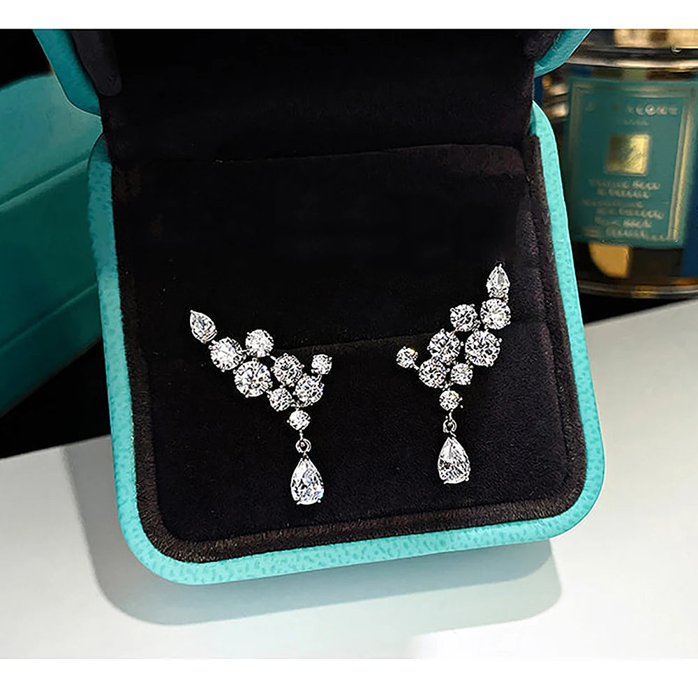Pair of silver earrings on a black and turquoise jewelry box
