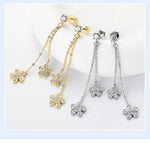 Butterfly-shaped earrings in gold and silver on a light background