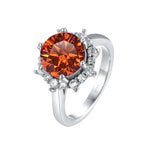 Silver ring with a large orange gemstone and smaller diamonds on a white background