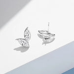 Silver leaf-shaped earrings on a light gray background