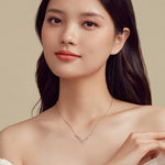 Woman wearing a delicate necklace against a neutral background