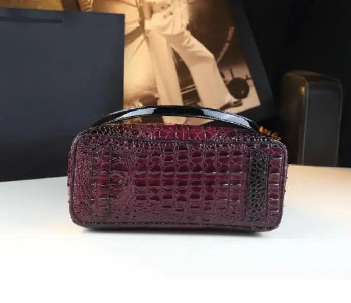 Purple textured handbag on a white surface with a blurred background