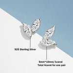 Silver leaf-shaped earrings with diamond-like stones on a light blue and white background.