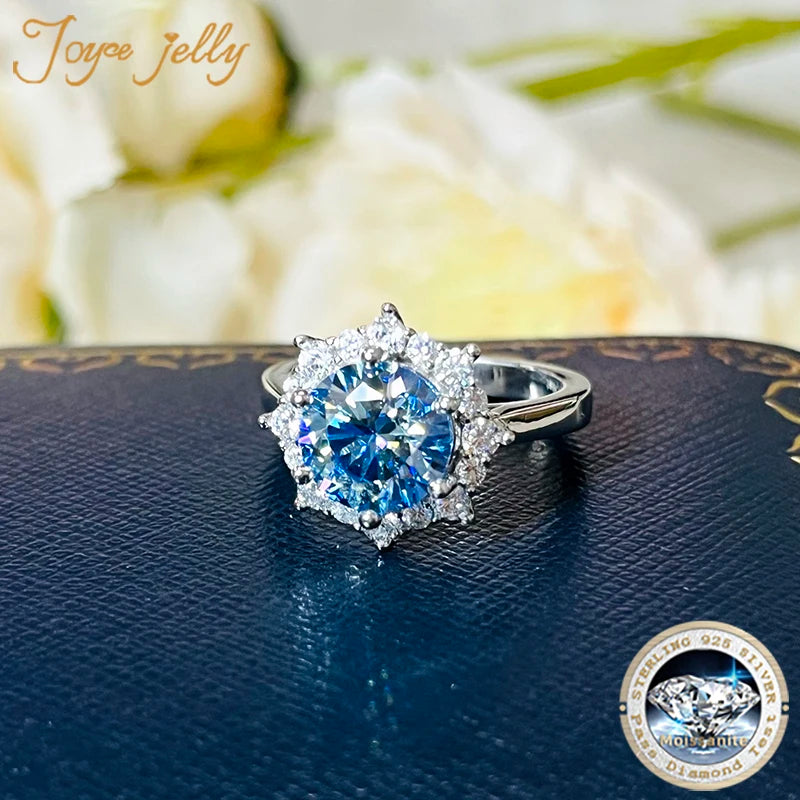 Silver ring with blue gemstone on a dark surface, brand 'Joyce Jelly' visible