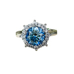 Silver ring with a blue gemstone on a white fabric background, featuring the brand 'Joyce Jelly'.