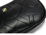 Close-up of a black textured product with gold logo on a white background