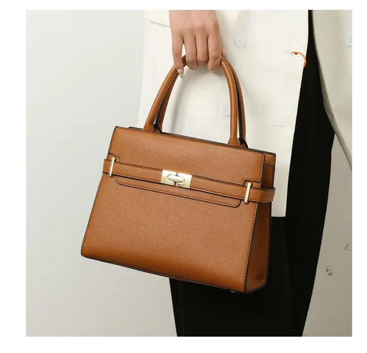 Brown handbag held by a person against a neutral background