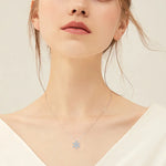 Necklace with a blue pendant worn by a model on a plain background