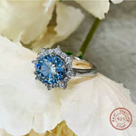 Silver ring with a blue gemstone on a white flower