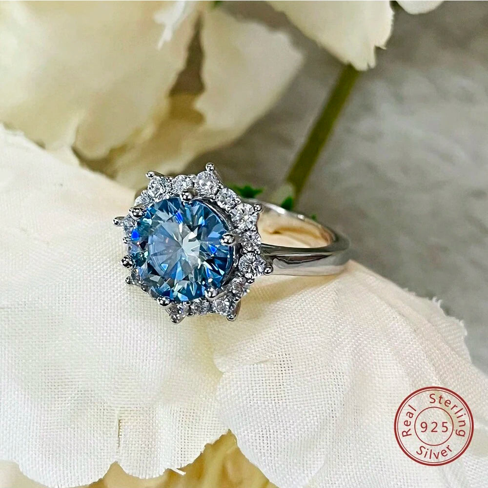 Silver ring with a blue gemstone on a white flower