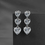 Pair of heart-shaped diamond earrings on a dark background