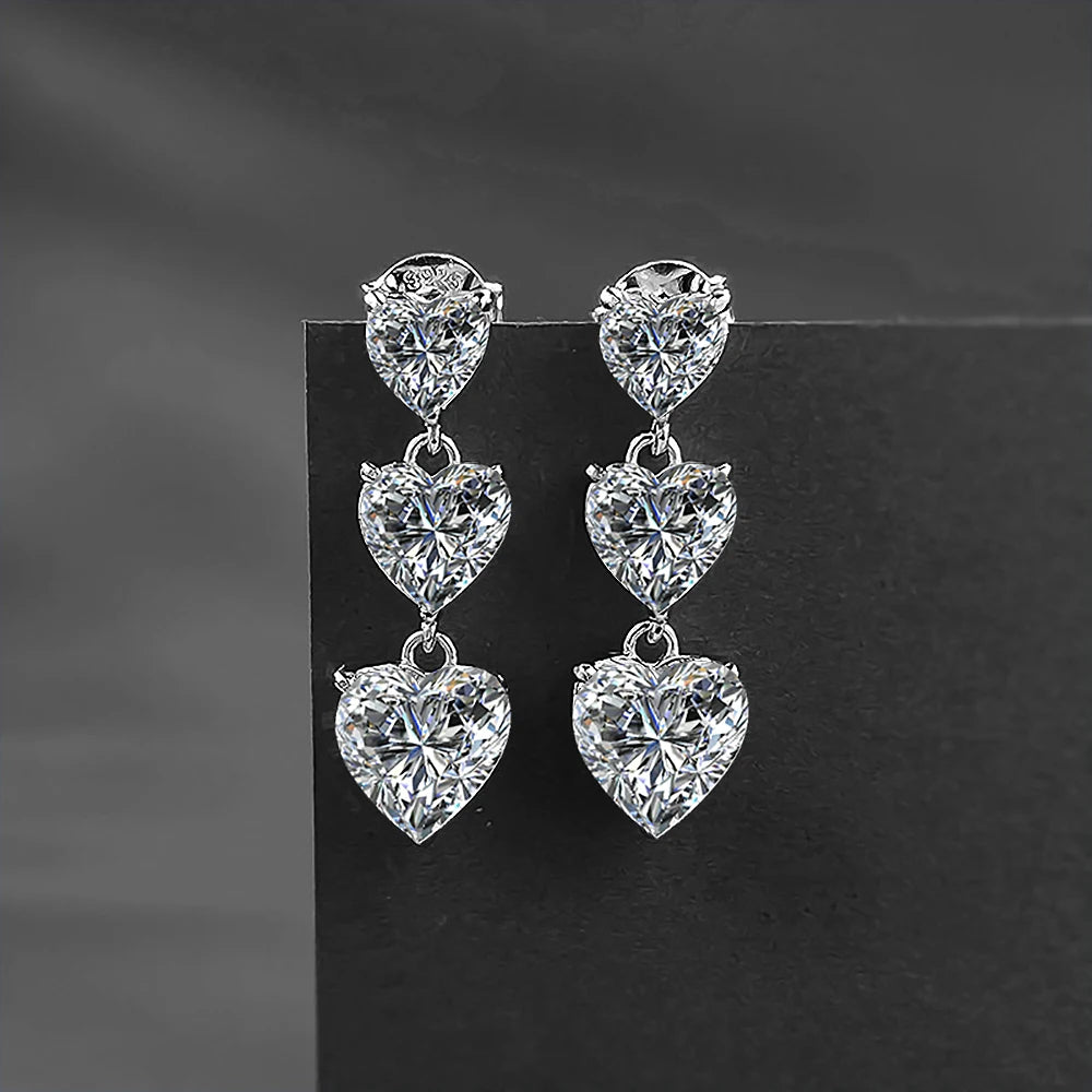 Pair of heart-shaped diamond earrings on a dark background