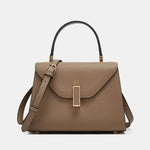 Brown handbag with a gold clasp on a light gray background