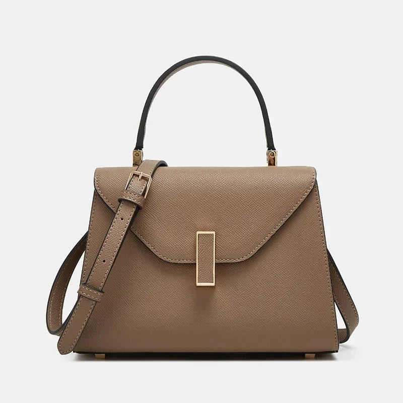Brown handbag with a gold clasp on a light gray background