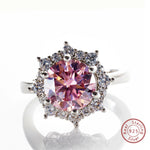 Ring with pink gemstone and diamond accents on a white background