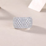 Silver ring with multiple rows of diamonds on a beige background