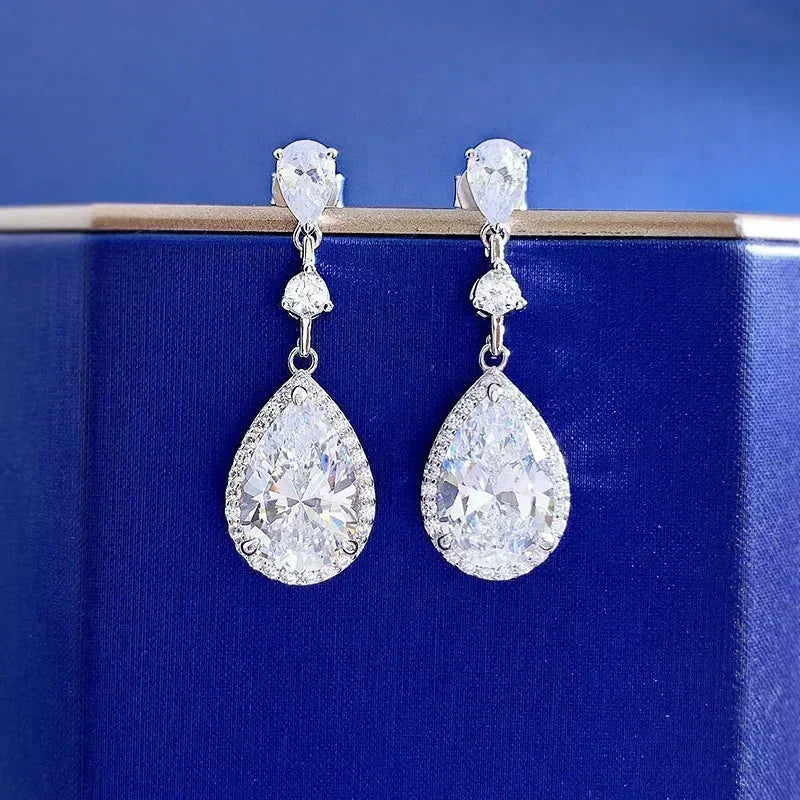 Teardrop-shaped diamond earrings on a blue background