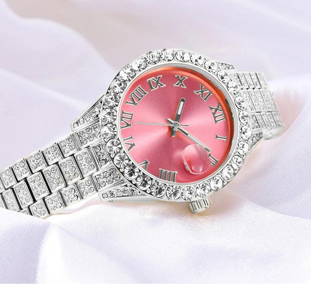 Silver watch with pink face and gemstones on a white background