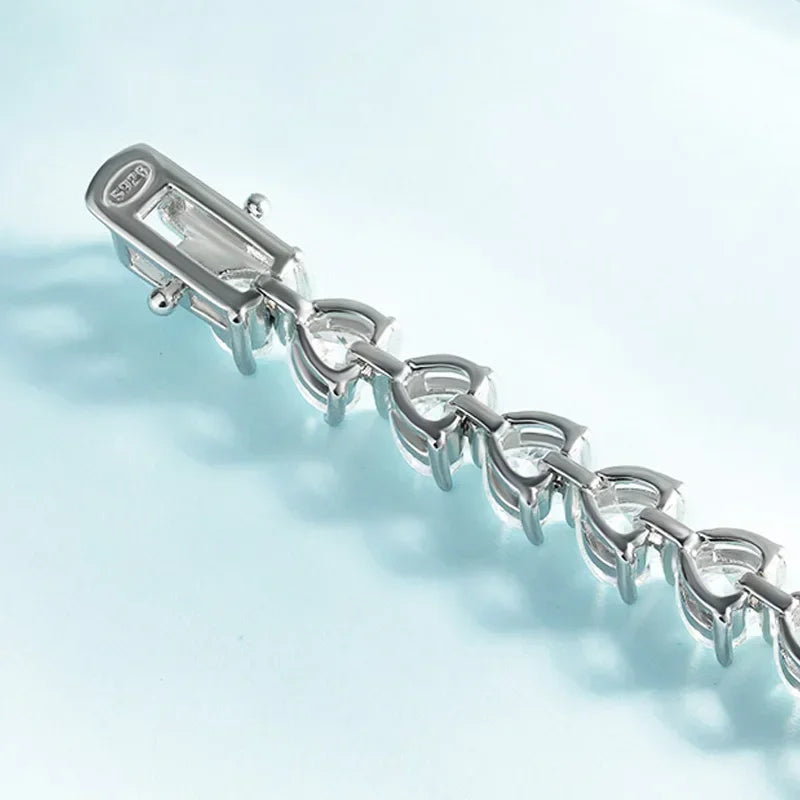 Silver bracelet with a clasp on a light blue background