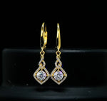 Gold earrings with diamond-like stones on a black background