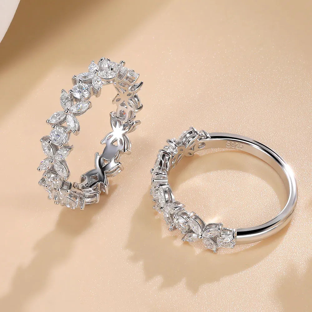 Pair of silver hoop earrings with clear gemstones on a beige background