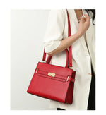 Red handbag held by a person wearing a white coat on a light gray background