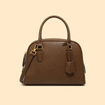 Brown leather handbag with gold accents on a beige background