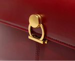 Red handbag with a gold clasp on a white background