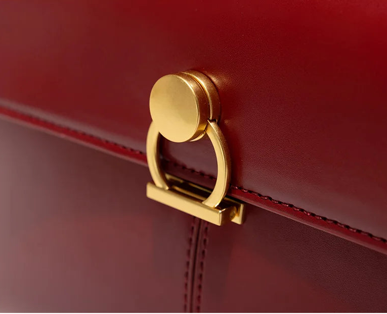 Red handbag with a gold clasp on a white background