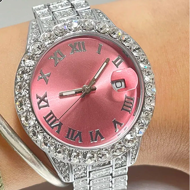 Pink watch with silver embellishments on a wrist