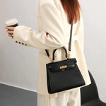 Person holding a black handbag and a coffee cup against a plain background