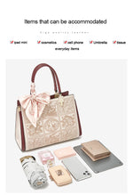 Handbag with lace detailing and its contents on a white background