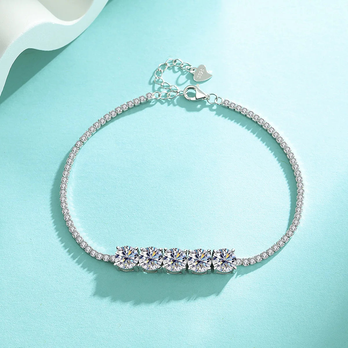 Silver bracelet with clear gemstones on a light blue background